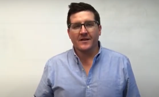 A person-with-glasses-wearing-a-blue-shirt